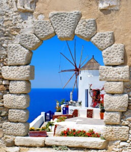 Windmill through an old window in Santorini island, Greece